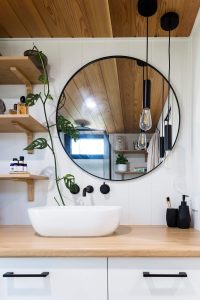 A round mirror installed on a bathroom wall